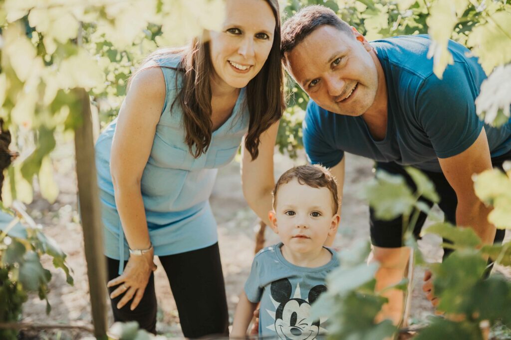 Eltern mit Kleinkind zwischen Weinreben, natürliches Familienfoto – Sabrina Dötzl Fotografie Hollabrunn