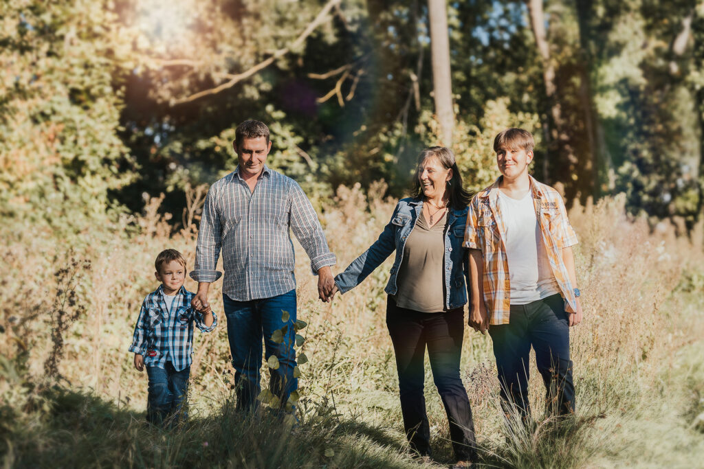 Familie spaziert Hand in Hand über eine Wiese im Herbst – Sabrina Dötzl Fotografie Hollabrunn