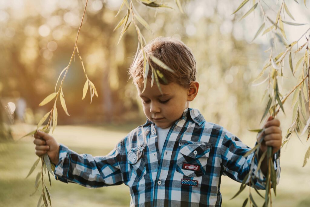 Kleiner Bub mit Weidenzweigen im karierten Hemd – Sabrina Dötzl Fotografie Hollabrunn
