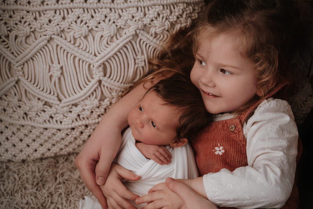 Große Schwester kuschelt mit dem neugeborenen Geschwisterchen – Sabrina Dötzl Fotografie Hollabrunn